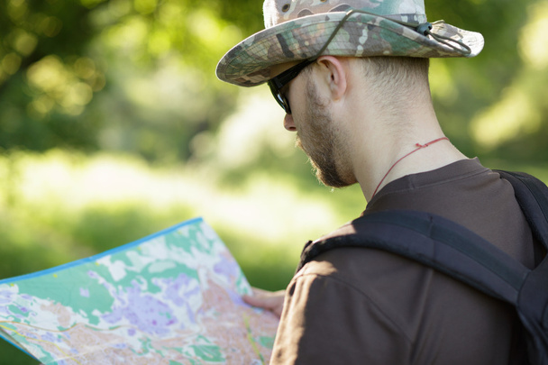 Male explorer looking at a map outdoors - Photo, image