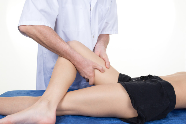 Handen van mannelijke fysiotherapeut masseren van het been van de vrouw - Foto, afbeelding
