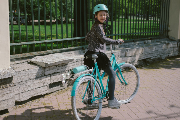 Teenage girl riding in a street with a bicycle  - Foto, imagen