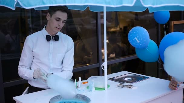 Özel bir makine üzerinde yapım pamuk şeker genç adam, balonlar arkasında papyon giyiyor - Video, Çekim