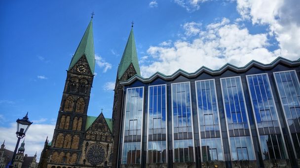 Bremen, Alemanha. Parlamento de Bremen Alemão: Bremische B rgerschaft e torres da Catedral de Bremen (em alemão: "Bremer Dom") em um dia ensolarado. Céu parcialmente nublado espelhado na enorme frente de vidro do edifício do governo
. - Foto, Imagem