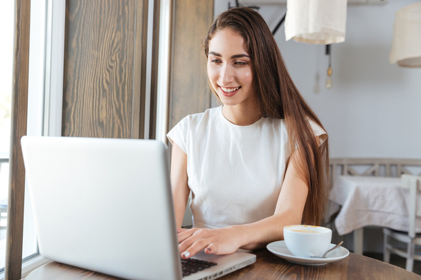 Pretty young business woman using laptop for work - Foto, Bild