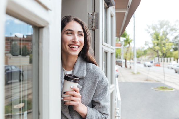Happy cheerful smiling girl holding take away coffee - Zdjęcie, obraz