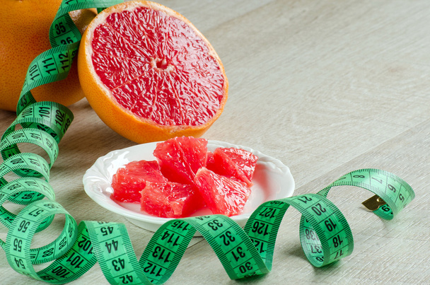 Výseče grapefruitu a měřicí pásky na stůl - Fotografie, Obrázek