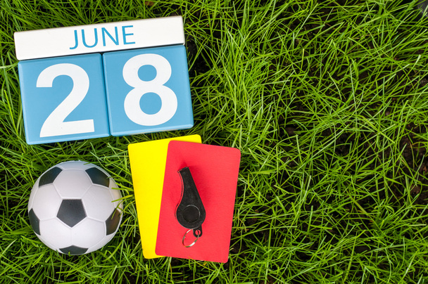 June 28th. Image of june 28 wooden color calendar on green grass background with football outfit. Summer day - Photo, Image