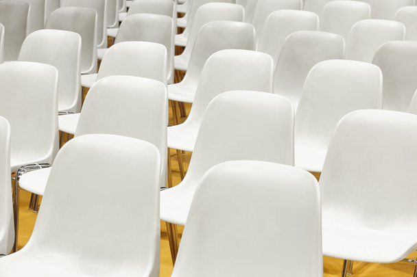 Konferenzraum mit Plastikstühlen und gelbem Boden. - Foto, Bild