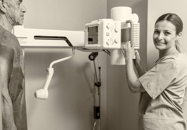Αρσενικός ασθενής στο ακτινολογικό μηχάνημα με γυναίκα γιατρό - Φωτογραφία, εικόνα