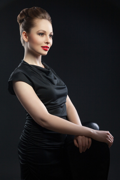 Young elegant woman in black dress near chair - Zdjęcie, obraz