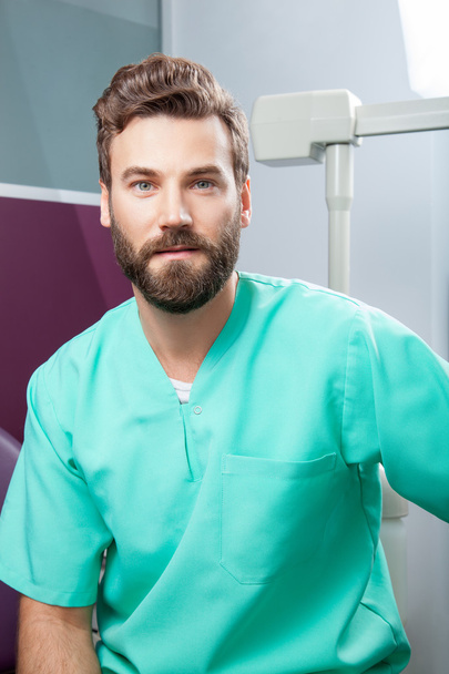 歯科医院で緑の衣装でひげの男性医師 - 写真・画像