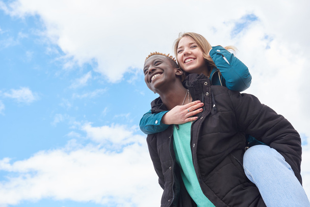 Loving Young International Couple on Sky Background. African Guy and Caucasian Woman - Photo, image