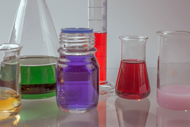 glas laboratoriumapparatuur met kleur water - Foto, afbeelding
