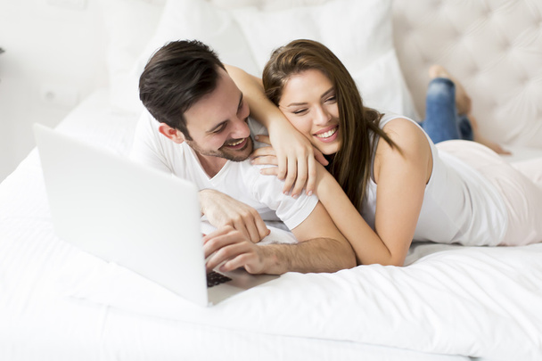 Yatağın içinde laptop ile genç Çift - Fotoğraf, Görsel