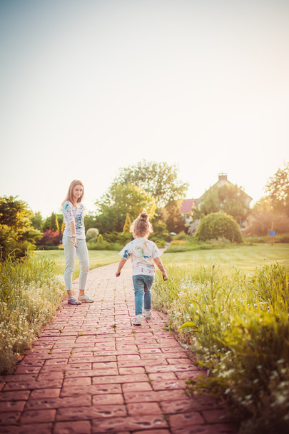 Mother and little daughter walking together - 写真・画像