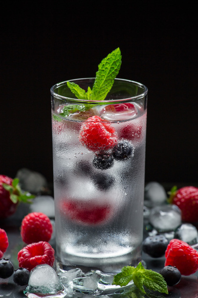 Mineral water with berries and ice cubes. - Foto, Imagen