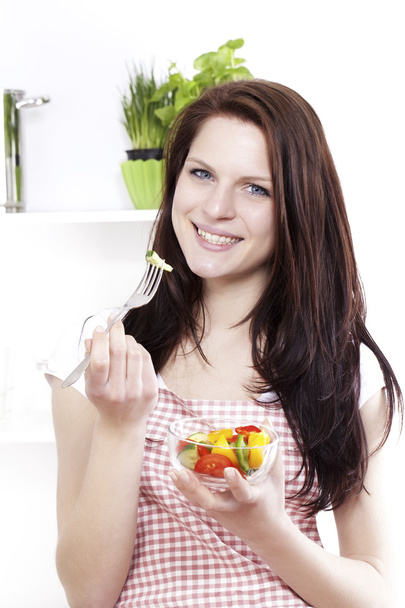 Young woman eating mixed salad - 写真・画像