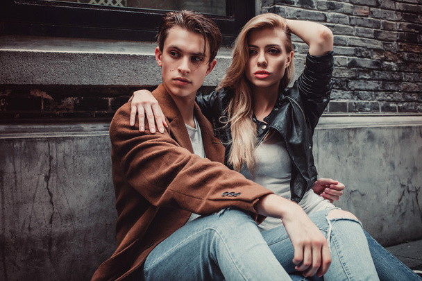 Joven hombre y mujer de moda posando en las paredes de ladrillo calle
 - Foto, imagen