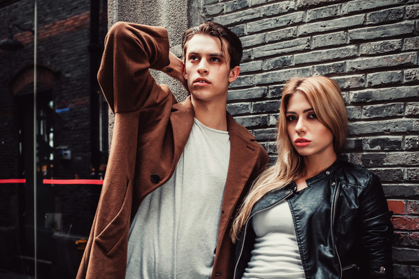 Young trendy man and woman posing in brick walls street - Fotografie, Obrázek