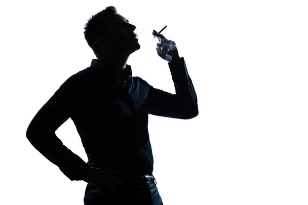 Silhouette man portrait smoking cigarette - Фото, изображение