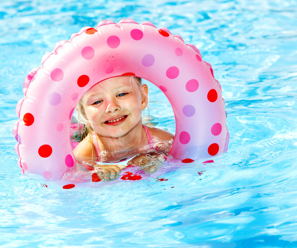 Niño sentado en anillo inflable en la piscina
. - Foto, imagen