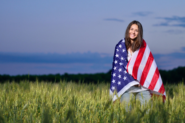 Lachende gelukkig meisje met de Amerikaanse vlag. 4 juli - Foto, afbeelding