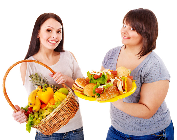Mujeres eligiendo entre fruta y hamburguesa
. - Foto, imagen