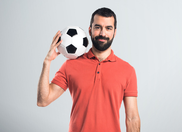 Красивый мужчина держит футбольный мяч
 - Фото, изображение
