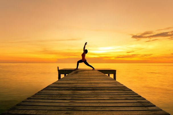 Yoga-Pose - Frau Silhouette praktiziert Yoga-Krieger Pose auf See - Foto, Bild