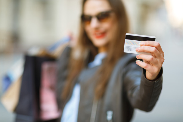 Beautiful woman with shopping bags and credit card in the hands  - Photo, Image