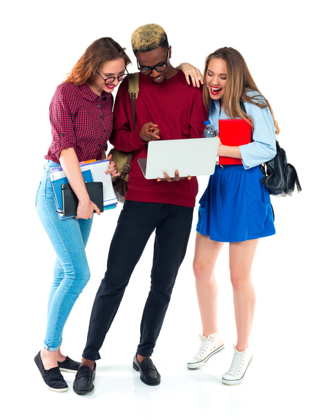 Happy students standing and smiling with books, laptop and bags  - Foto, Bild