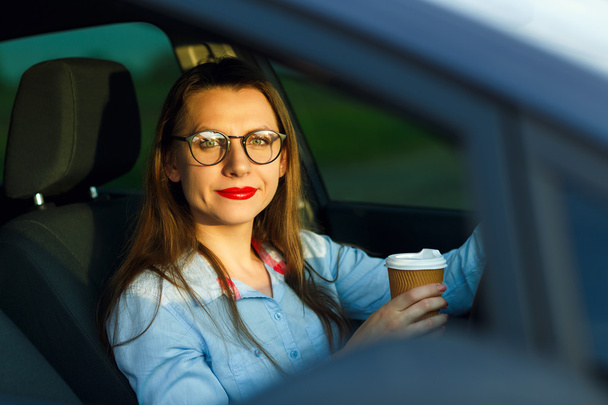 Young woman with coffee to go driving her car - Fotografie, Obrázek