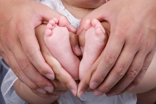 Pies de bebé, manos de padre y madre
 - Foto, Imagen