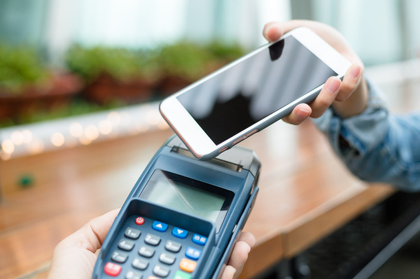 Kobieta za pomocą telefonów komórkowych za zapłacenie rachunku - Zdjęcie, obraz