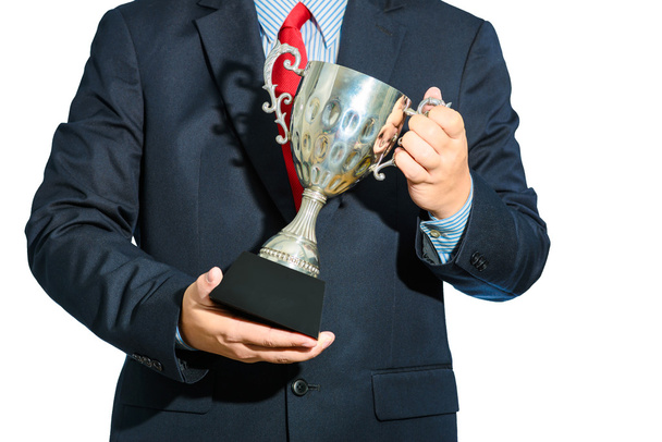 Бізнесмен, переможець з костюмом, що тримає трофей на білому фоні
 - Фото, зображення
