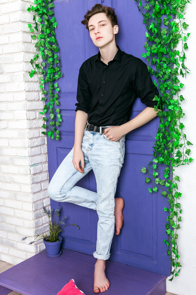 handsome guy dressed in black shirt and jeans posing - Photo, Image