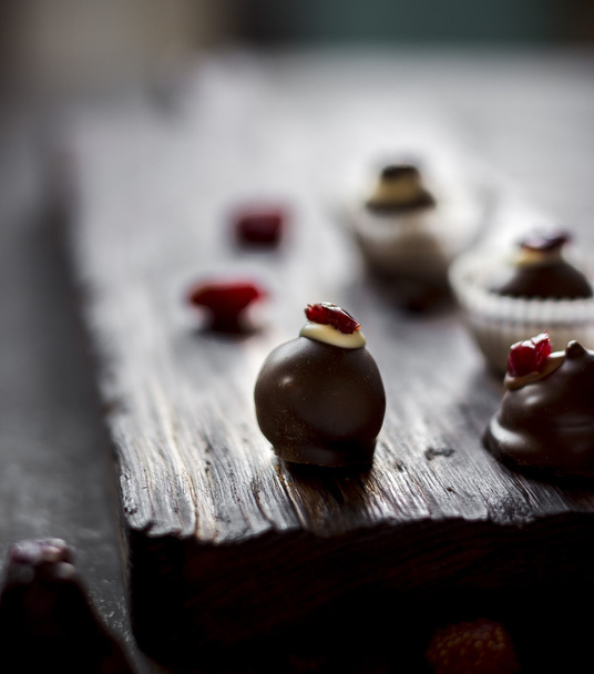 Chocolate sweets with dried berries and chocolate beans. - Valokuva, kuva