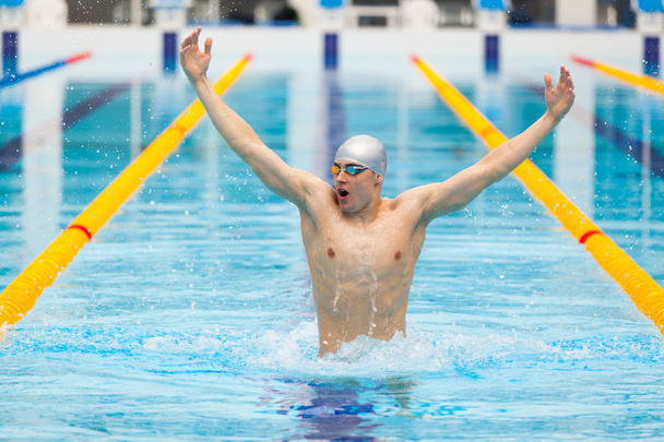 dynamic and fit swimmer in cap breathing performing jumping out the water, concept of victory, freedom, happiness, healthy lifestyle - Φωτογραφία, εικόνα