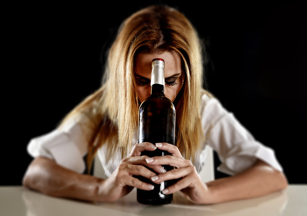 drunk alcoholic blond woman alone in wasted depressed with red wine bottle suffering hangover - Photo, Image