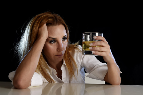 п'яна алкогольна жінка марнувала і пригнічувала тримаючись, дивлячись вдумливо на шотландське віскі
  - Фото, зображення