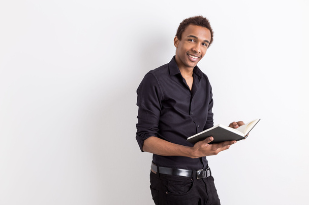 Black guy holding book - Фото, изображение