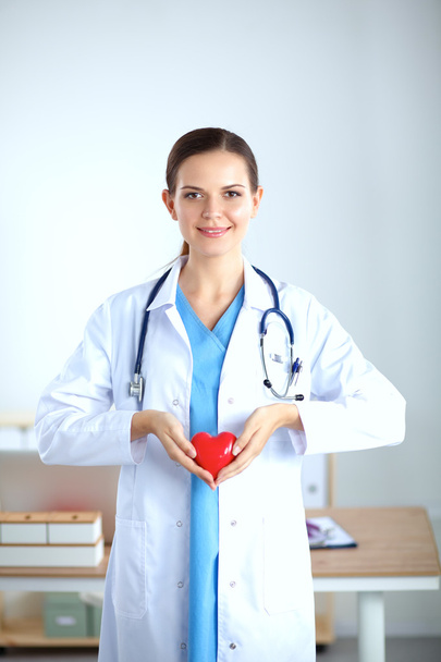 Female doctor with stethoscope holding heart - Foto, Imagem
