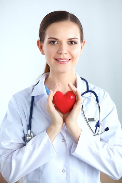 Female doctor with stethoscope holding heart - Foto, Imagen