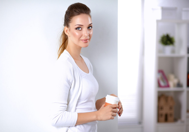 Attractive young businesswoman standing near wall in office - Foto, immagini