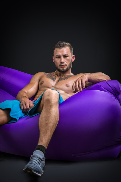 Portrait of relaxed sexy man sitting on air chair - Foto, Imagem
