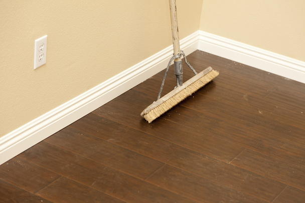 Push Broom on a Newly Installed Laminate Floor and Baseboard - Photo, Image
