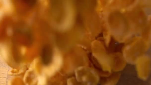 Pouring corn flakes into glass bowl super slow motion shot, view from above - Video