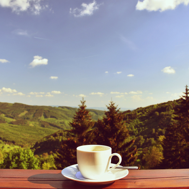 Manhã xícara de café com um belo fundo paisagem montanha
 - Foto, Imagem