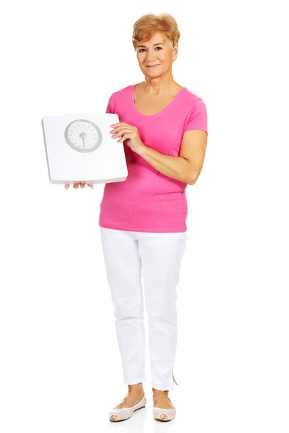 Smiling old woman holding weight scale - Photo, image