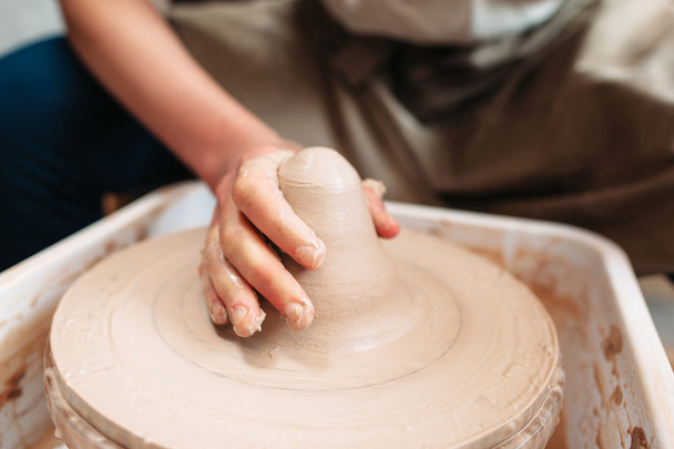 Hand of potter on clay at workplace - Foto, Imagen