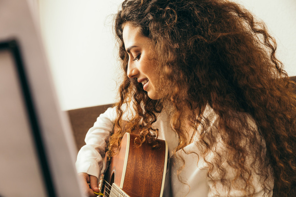 Young girl with long hair playing of guitar - Foto, afbeelding