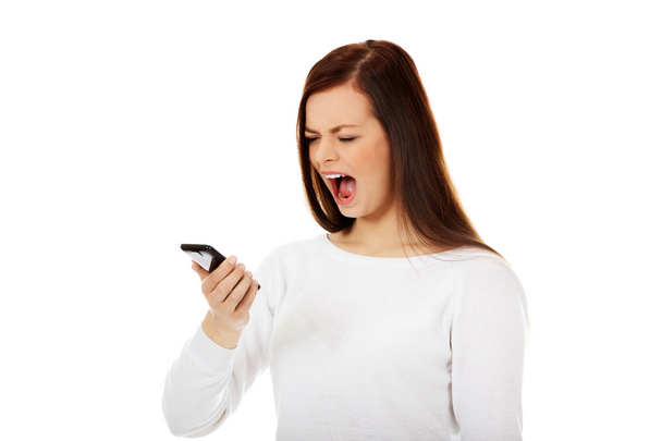 Young student woman yelling to the mobile phone - Фото, изображение
